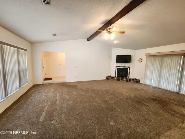 a view of a livingroom with an empty space and a window