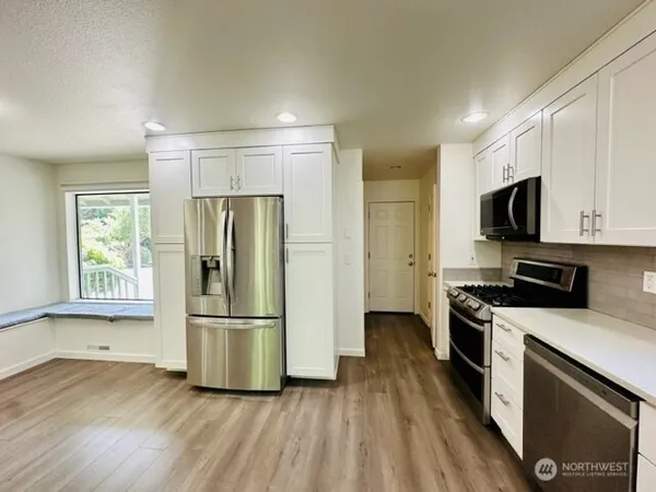 a kitchen with stainless steel appliances granite countertop a refrigerator microwave and stove top oven