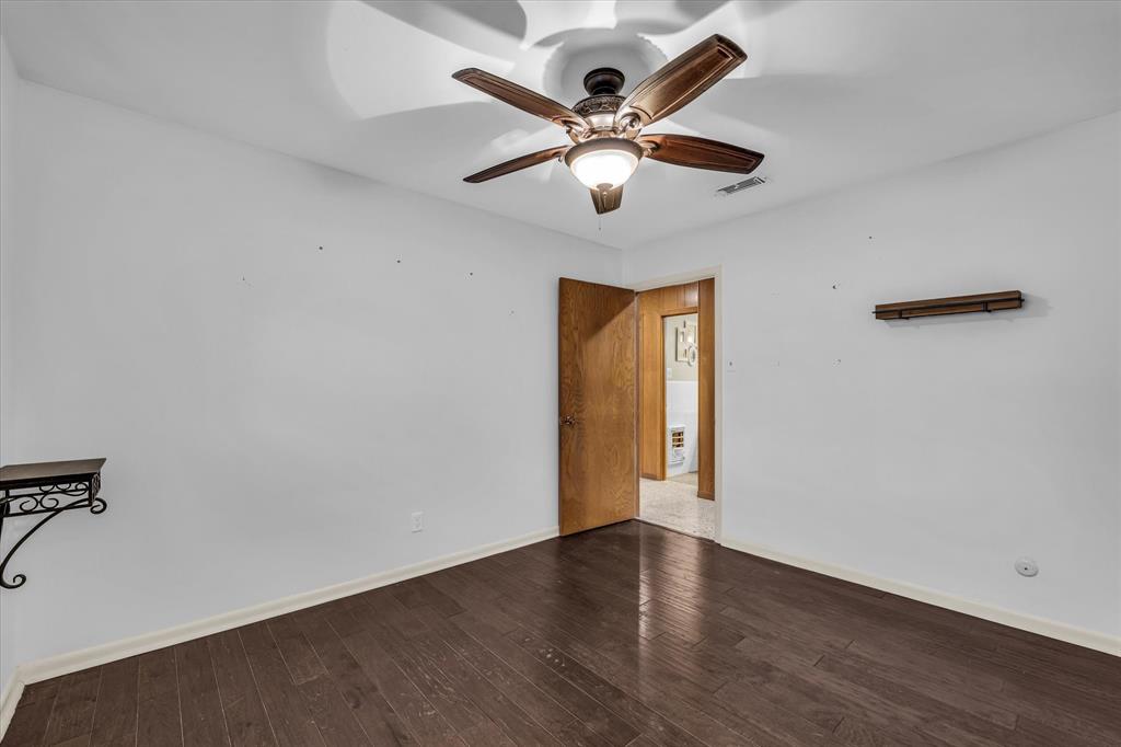 4325 Shady Glen Drive Waco, TX 76708 - Photo 22 of 40 an empty room with wooden floor and a ceiling fan