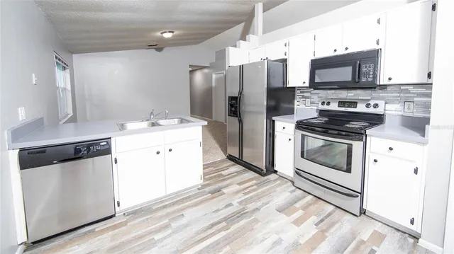 a kitchen with stainless steel appliances a stove a sink and a refrigerator