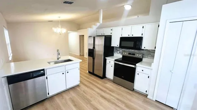 a large white kitchen with stainless steel appliances