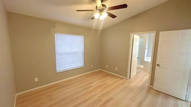 an empty room with closet and a chandelier fan