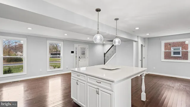 a view of a kitchen with a sink wooden floor and a chandelier