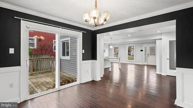 a view of a hallway with wooden floor and a chandelier