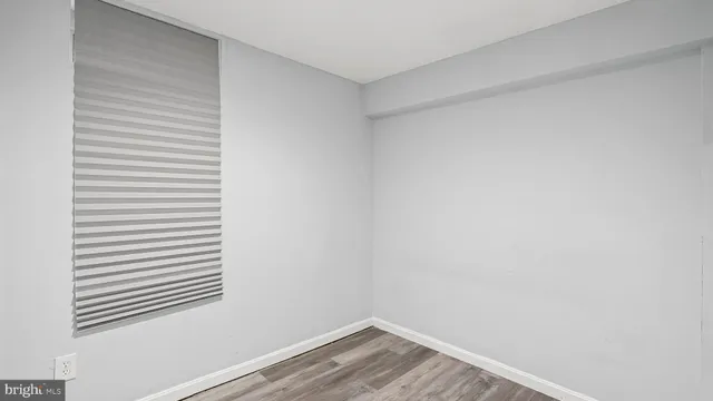 a view of a small space with wooden floor and a window