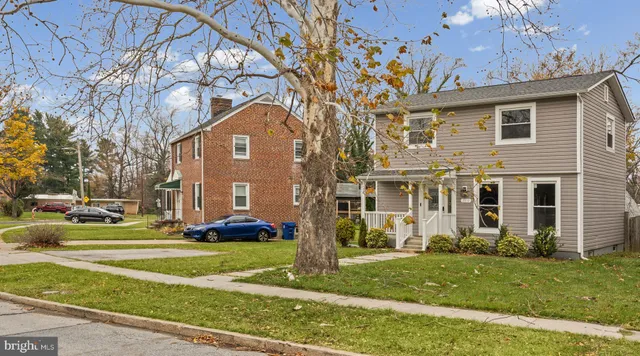 a front view of a house with a yard and trees