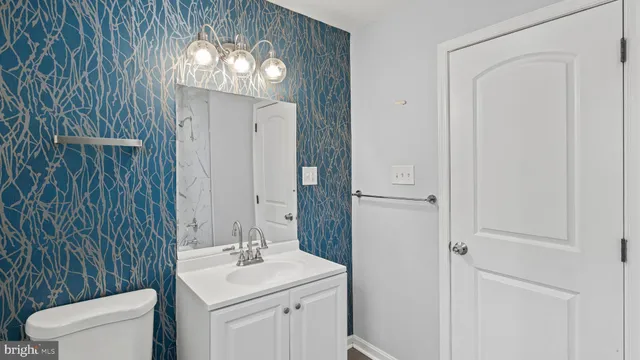 a bathroom with a toilet a sink a mirror a vanity and window