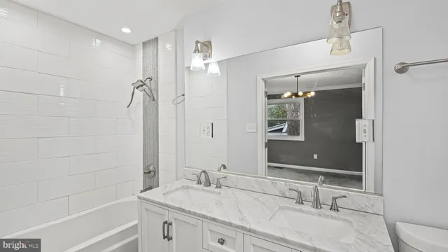a bathroom with a granite countertop sink a toilet and shower