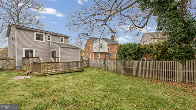 a view of a house with a yard and a large tree