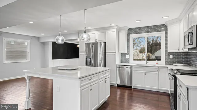 a kitchen with stainless steel appliances kitchen island granite countertop a stove a sink and a refrigerator