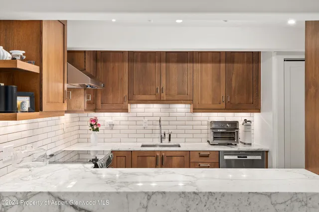 a kitchen with stainless steel appliances granite countertop a sink and a wooden cabinets
