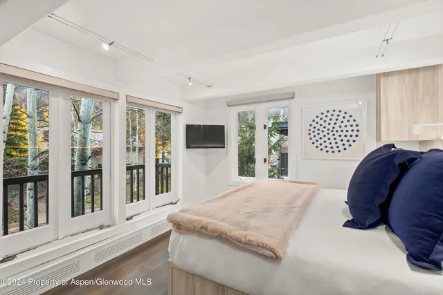 a spacious bedroom with a large bed and a large window