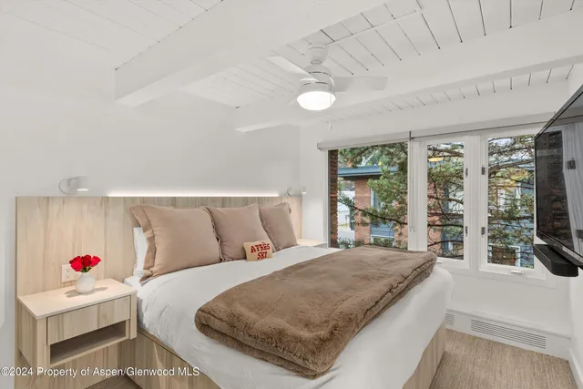 a bedroom with a large bed and a large window