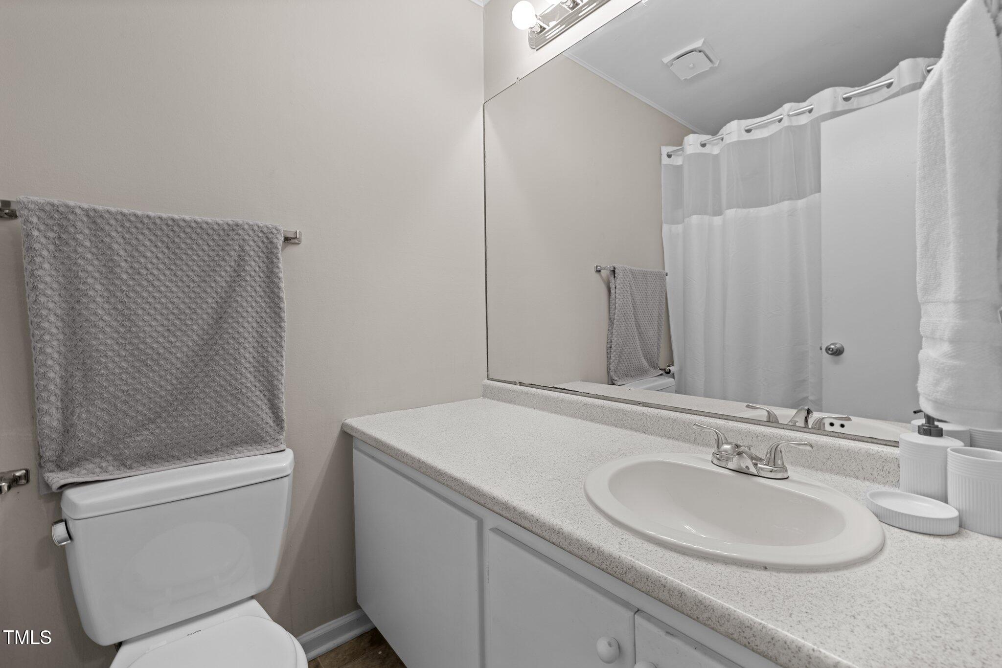 6230 Dixon Drive Raleigh, NC 27609 - Photo 22 of 32 a bathroom with a sink toilet and a mirror