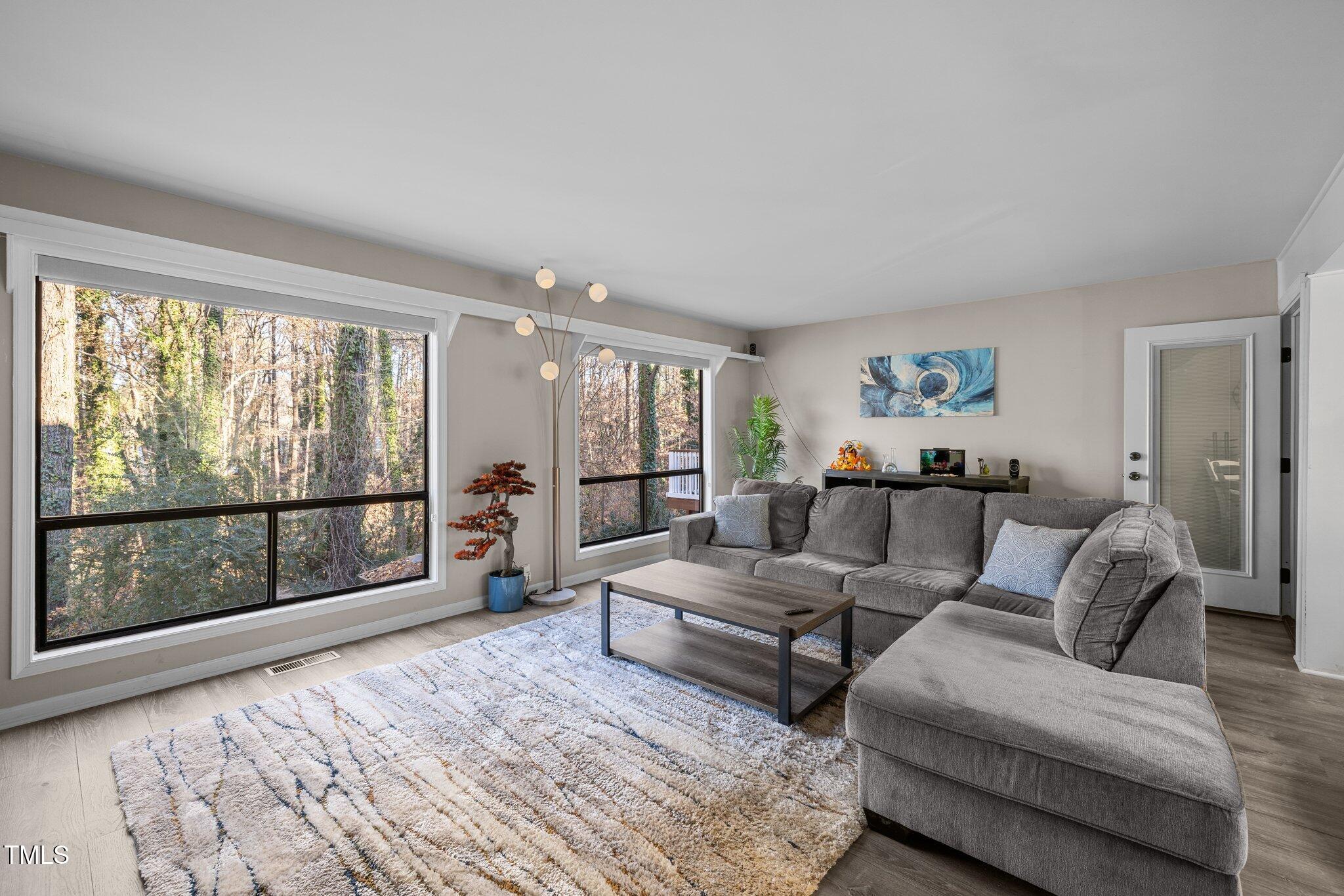 6230 Dixon Drive Raleigh, NC 27609 - Photo 10 of 32 a living room with furniture large windows and wooden floor