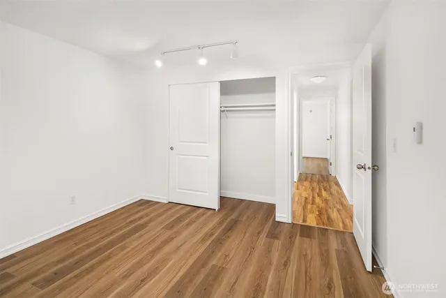 a view of a room with wooden floor and a hallway