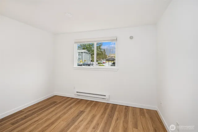 a view of a room with wooden floor and small window