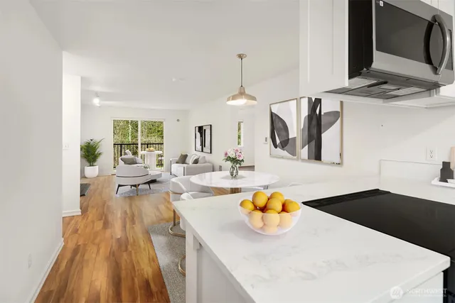 a living room with kitchen island granite countertop furniture a rug and a painting