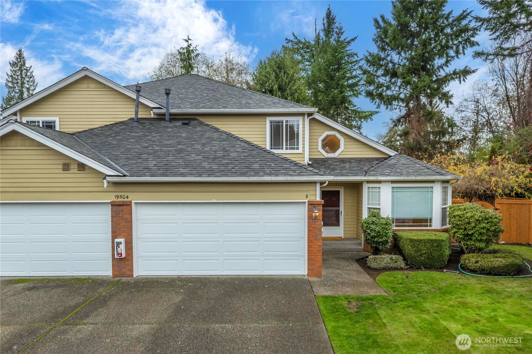 19504 Southeast 24th, Unit B Bothell, WA 98012 - Photo 1 of 34 a front view of house with yard and trees in the background