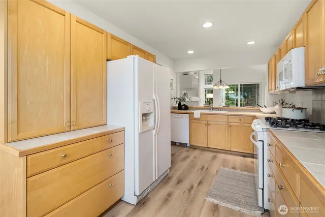 a kitchen with white cabinets and white appliances