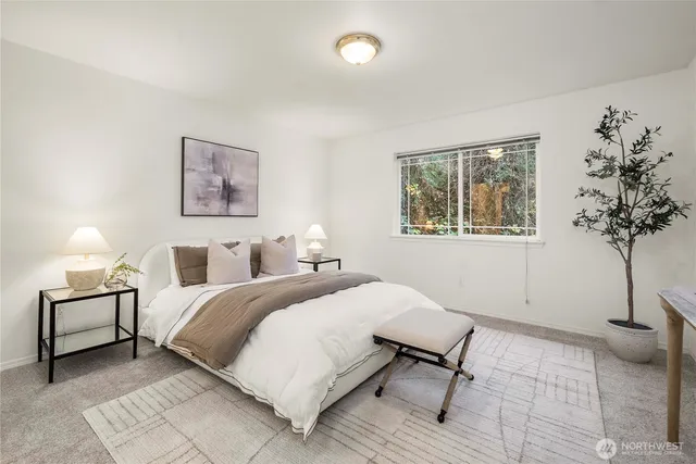 a bedroom with a bed lamp and a potted plant