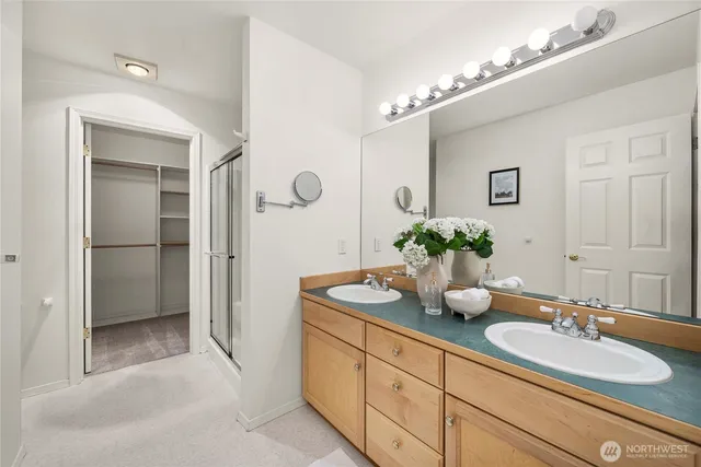 a bathroom with a granite countertop sink a mirror and a shower