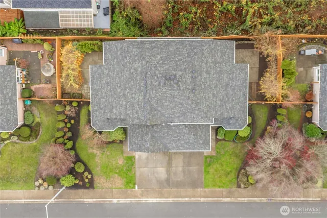 an aerial view of a house with a yard and large tree