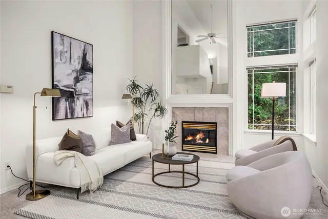 a living room with furniture a fireplace and a large window