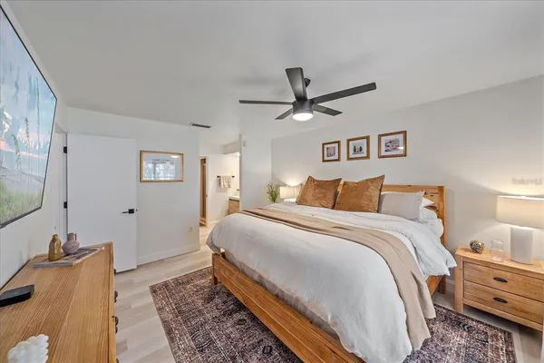 a bedroom with a large bed and a chandelier