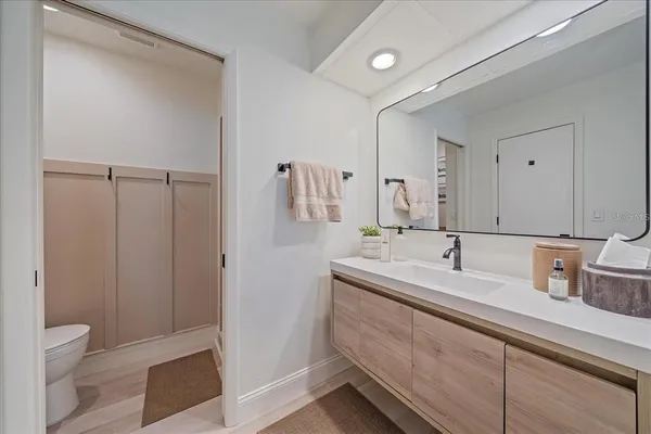 a bathroom with a sink a toilet and a large mirror