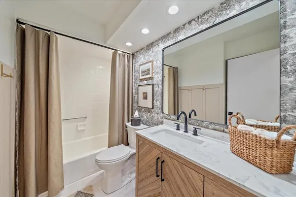 a bathroom with a double vanity sink toilet and shower