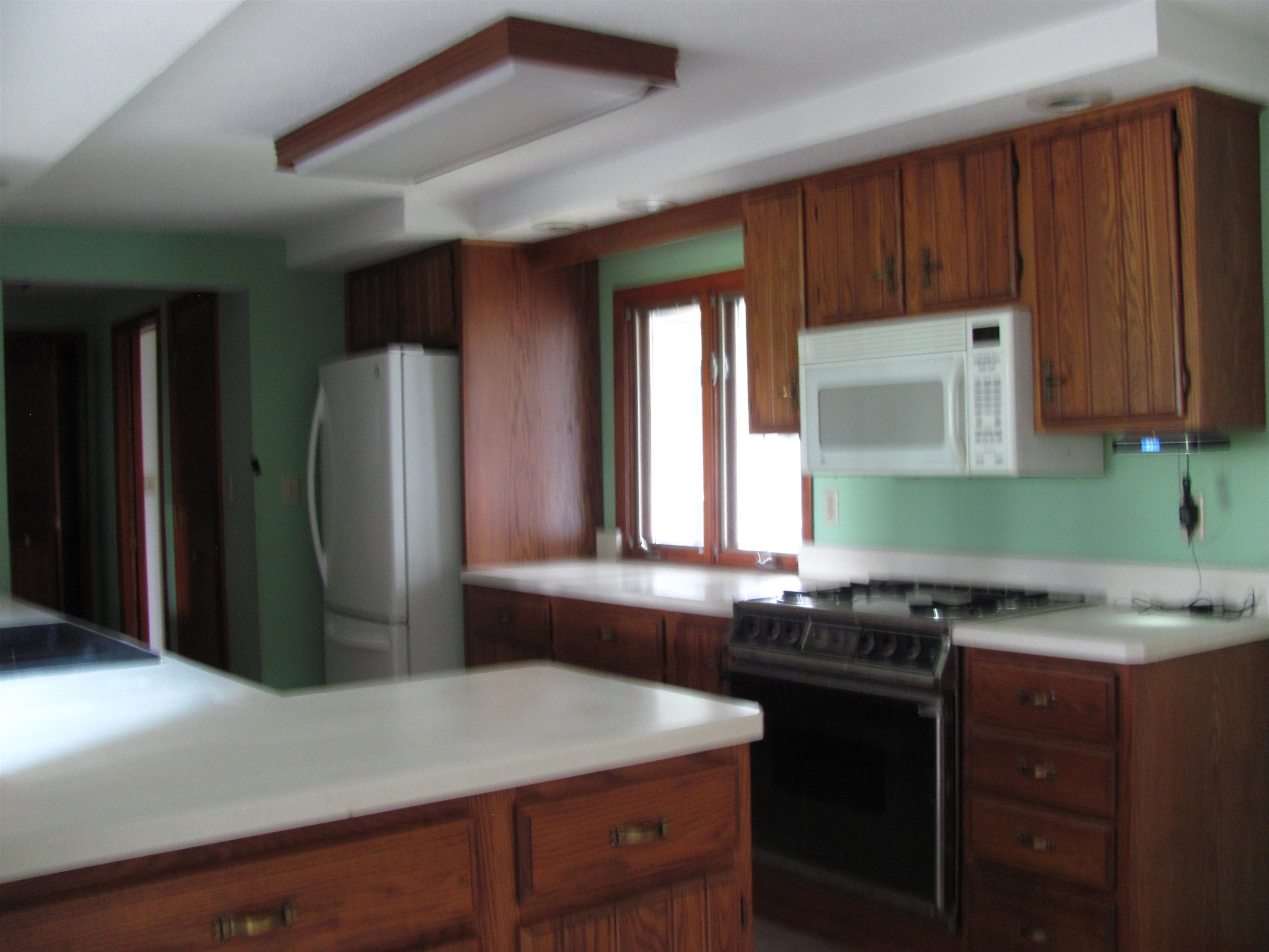 6159 Prairie Road Rockford, IL 61102 - Photo 4 of 47 a kitchen with a sink a refrigerator and cabinets