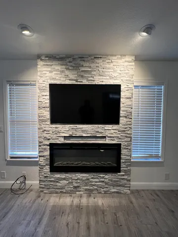 a view of living room with a flat screen tv and a fireplace