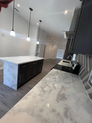 a large kitchen with kitchen island a sink stainless steel appliances and a floor