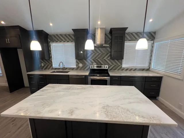 a kitchen with a sink a counter space and stainless steel appliances