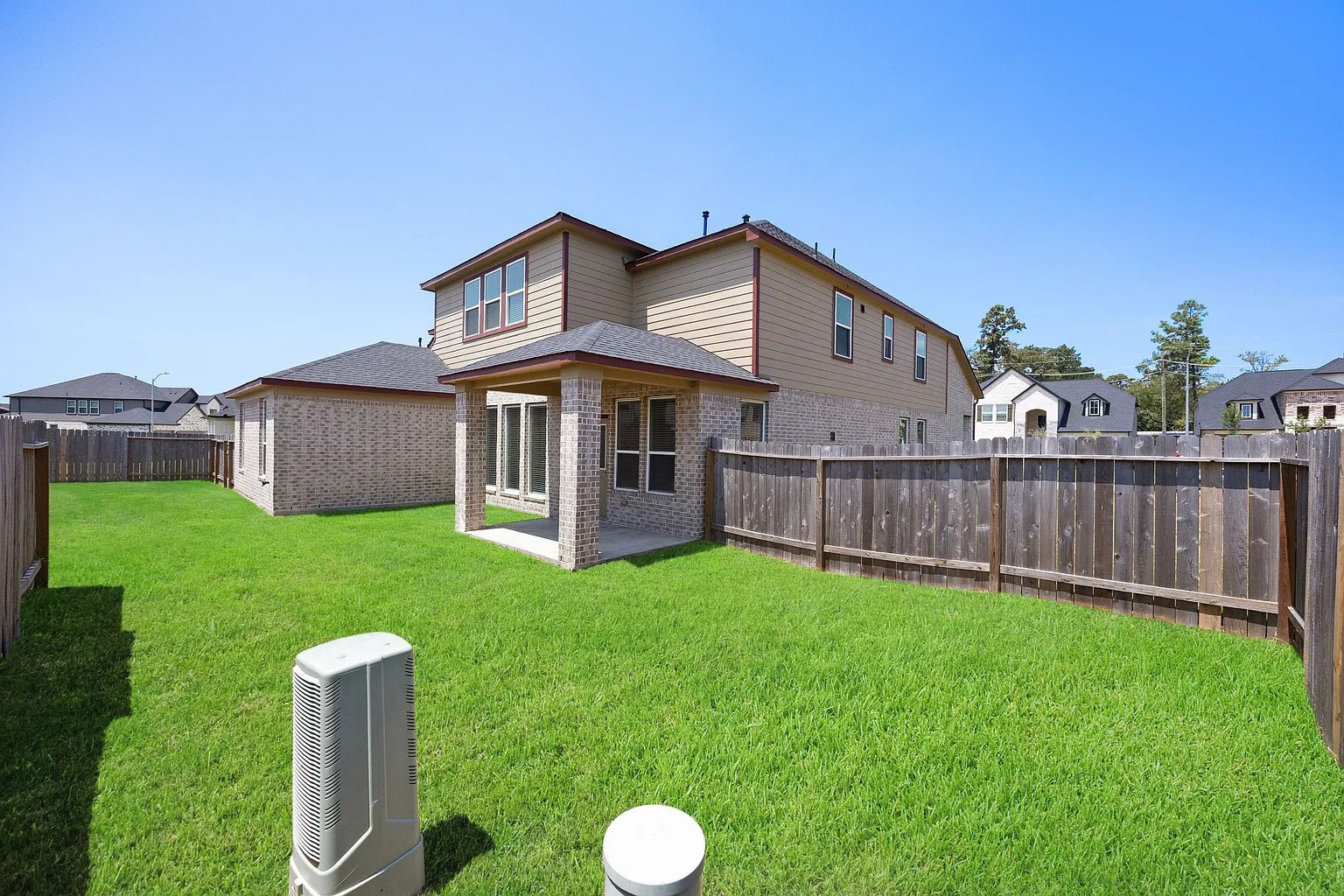 3018 North Spring Drive Spring, TX 77373 - Photo 24 of 25 Spacious backyard with lush green grass, perfect for outdoor activities, enclosed by a sturdy wooden fence for added privacy.