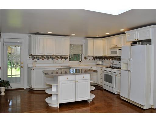 2565 Meinert Road Franklin Park, PA 15090 - Photo 12 of 18 Kitchen. Lower Level boasts a very spacious kitchen with crisp white cabinetry, center island, recessed lighting, gas stove, refrigerator, dishwasher, access to deck, white countertops, eat-in-area, hardwood floors and access to separate outside entrance.