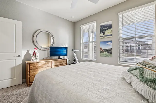 a bedroom with a bed and a large window with outer view