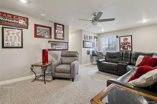 a living room with furniture and a ceiling fan