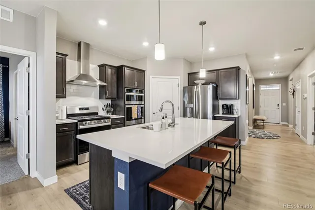 a kitchen with stainless steel appliances kitchen island granite countertop a kitchen island a stove a table and chairs