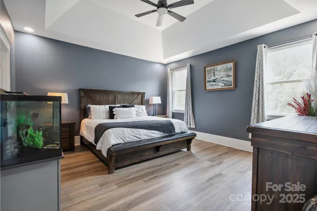 a bedroom with a bed and a dresser with wooden floor