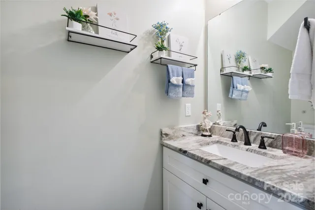a bathroom with a granite countertop sink a mirror and vanity
