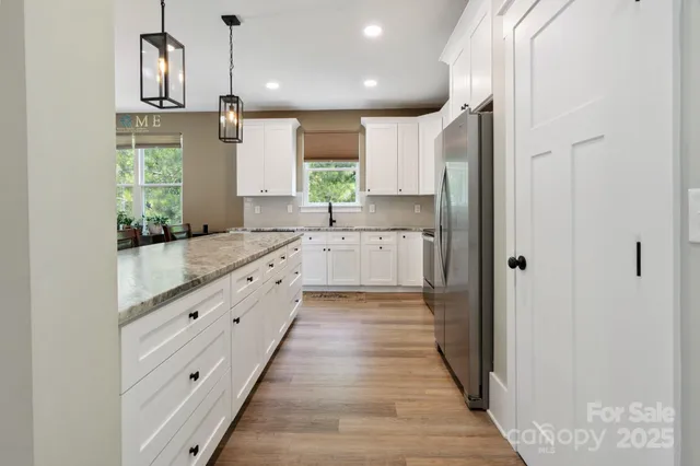 a large kitchen with a lot of counter space and a wooden floor