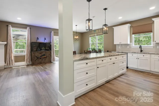 a large kitchen with a lot of counter space and wooden floor