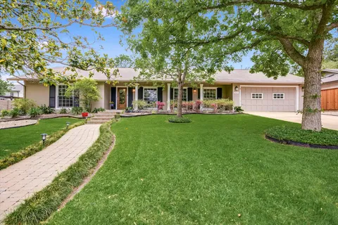 a front view of a house with a yard and trees