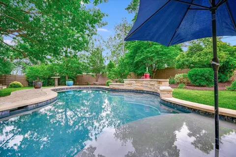 a view of a backyard with a table and chair under an umbrella