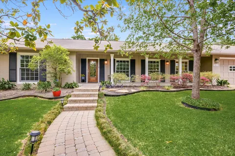 a front view of a house with garden and outdoor seating