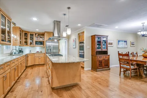 a large kitchen with stainless steel appliances kitchen island granite countertop a large island in the center