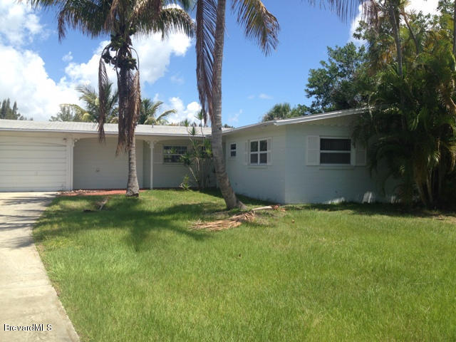 1081 Bali Road Cocoa Beach, FL 32931 - Photo 2 of 17 a backyard of a house with plants and palm trees