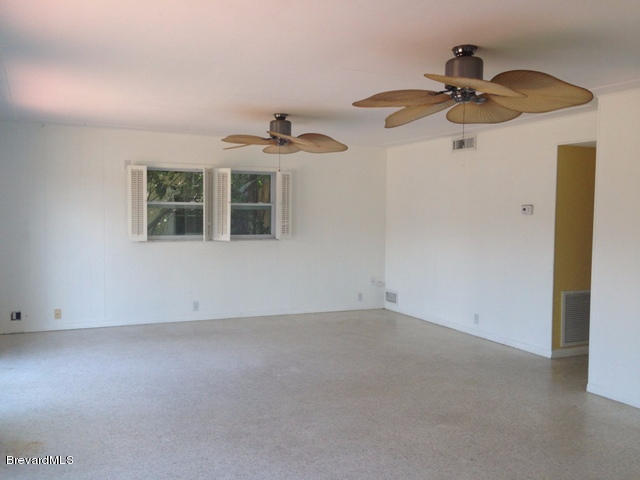 1081 Bali Road Cocoa Beach, FL 32931 - Photo 3 of 17 a view of a room with a ceiling fan and a window